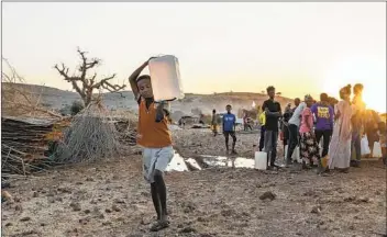  ?? NARIMAN EL-MOFTY AP ?? A boy who f led the conf lict in Ethiopia’s Tigray region carries water at Umm Rakouba refugee camp in Qadarif, eastern Sudan, on Friday. Ethiopia’s prime minister again ruled out dialogue with Tigray leaders.
