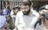  ?? Files/ AFP ?? Pakistani police surround handcuffed Omar Sheikh as he comes out of a court in Pakistan’s port city of Karachi.