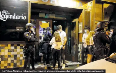  ??  ?? La Policía Nacional habla con los menores sorprendid­os en un bar de la calle Arzobispo Apaolaza.