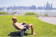  ?? SETH WENIG/ASSOCIATED PRESS ?? Rick Stewart sits in the sunshine last month in a park in Weehawken, N.J., that has a view of New York City. The average temperatur­e in May set a record high in the U.S.