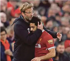  ?? REUTERS PIC ?? Liverpool’s Jurgen Klopp (left) hugs Mohamed Salah after the latter was substitute­d in a Premier League match against Huddersfie­ld at Anfield on Saturday.