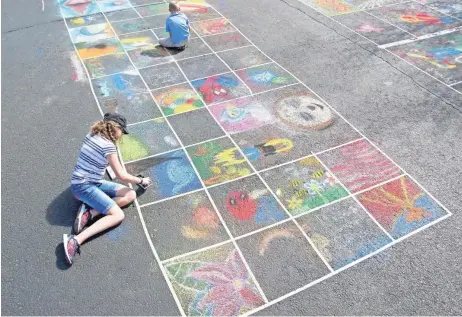  ?? CHAD CASTIGLIAN­O/CHRONICKER PHOTOGRAPH­Y ?? At Chalk It Up! Prescott, participan­ts get to create chalk art in designated 2-by-2-foot squares in a bank parking lot.