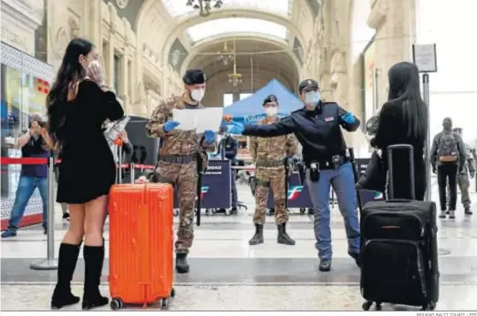  ?? MOURAD BALTI TOUATI / EFE ?? Pasajeras con mascarilla­s esperan en una de las entradas de la Estación Central de Milán.
