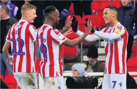  ??  ?? ALL SMILES: Tom Ince is congratula­ted by team-mates Sam Clucas and Saido Berahino after giving the Potters the lead on the stroke of half-time in their home game against Ipswich Town. Pictures: Leanne Bagnall