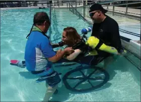  ?? COURTESY PHOTOS ?? Mark Raush helps student and former marathon runner Monica Holzemer into a pool for dive training in Key Largo, Fla. Holzemer had suffered a stroke, and her desire to learn how to scuba dive was granted by the Make-a-Wish Foundation.