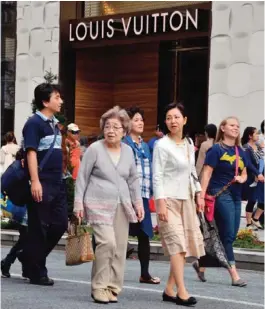  ??  ?? TOKYO: Shoppers strolling at Tokyo’s Ginza shopping district. Japanese Premier Shinzo Abe’s long-awaited decision this week on whether to hike sales taxes is a major political gamble that proved career-ending for his predecesso­rs, analysts say. — AFP