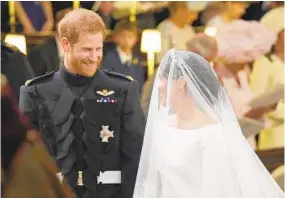  ?? JONATHAN BRADY/AFP/GETTY IMAGES ?? Prince Harry and his fiancee, Meghan Markle, arrive at the altar for their wedding ceremony, presided over by the archbishop of Canterbury.