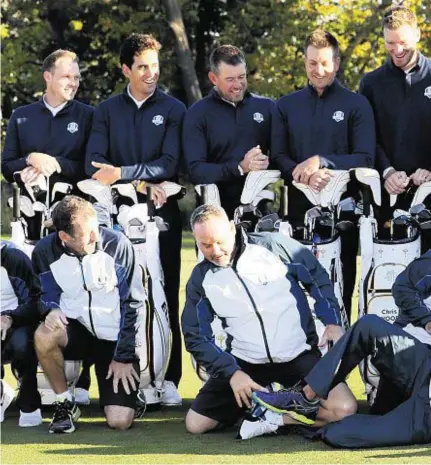  ??  ?? TAKING A TUMBLE: The European team’s caddies found it difficult to stay on their feet as the players posed for