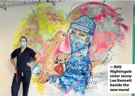  ??  ?? > NHS Nightingal­e sister JennyLee Bennett beside the new mural