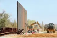  ?? AP PHOTO/MATT YORK ?? Government contractor­s erect a section of Pentagon-funded border wall Tuesday along the Colorado River in Yuma, Ariz.