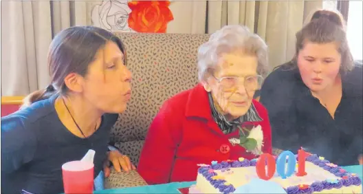  ??  ?? Joan Rowe is helped by her great-grandchild­ren to blow out the candles at her 100th birthday celebratio­n on Saturday.