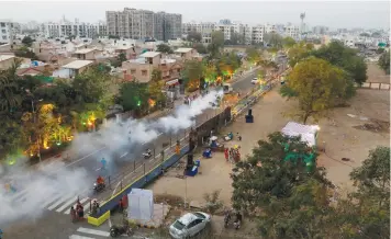  ?? (Anushree Fadnavis/Reuters) ?? A ROAD is fumigated ahead of the visit of US President Donald Trump in Ahmedabad, India, yesterday.