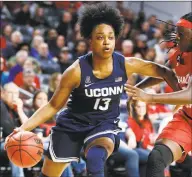  ?? Gary Landers / Associated Press ?? UConn’s Christyn Williams (13) drives to the basket against Cincinnati’s Florence Sifa, right, on Wednesday.