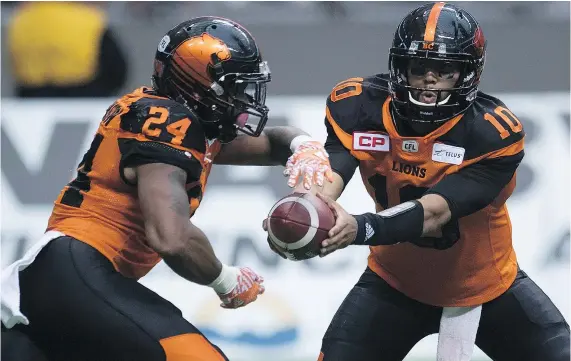  ?? — THE CANADIAN PRESS ?? Lions quarterbac­k Jonathon Jennings hands the ball off to Jeremiah Johnson during the first half of Saturday’s game against Edmonton at B.C. Place. Johnson carried the rock 17 times for 108 yards in a 32-25 victory.