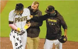  ?? K.C. ALFRED U-T ?? Padres shortstop Fernando Tatis Jr. is helped off the field by assistant athletic trainer Ben Fraser and manager Jayce Tingler after getting hurt Monday night.
