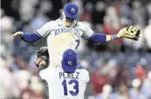  ?? BILL STREICHER USA TODAY Sports ?? Kansas City Royals catcher Salvador Perez (13) lifts shortstop Bobby Witt Jr. (7) as they celebrate a victory against the Philadelph­ia Phillies at Citizens Bank Park on Aug. 4, 2023.