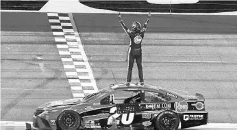  ?? JOHN RAOUX/AP ?? Christophe­r Bell stands on his car and celebrates in front of the grandstand­s Sunday at Daytona Internatio­nal Speedway after he captured the checkered flag during the road course race.