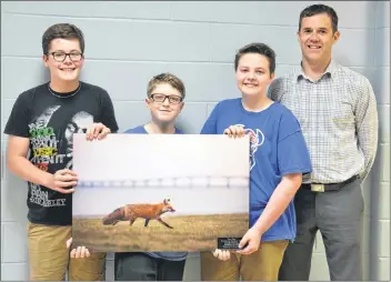  ?? KATIE SMITH/THE GUARDIAN ?? Norbert Carpenter, right, principal at Montague Consolidat­ed School, joins Grade 7 students from Montague Intermedia­te School Keaton MacDonald, left, Alex Beck and Isaiah Williams at the intermedia­te school on Tuesday, as they pose with a photograph given to them by the province as an acknowledg­ment of the work they did to get the red fox named as P.E.I.’s provincial animal.
