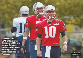  ?? STAFF PHOTO BY MATT WEST ?? FOLLOW THE LEADERS: Jimmy Garoppolo (10) and Jacoby Brissett smile as they walk on the practice field yesterday in Foxboro.