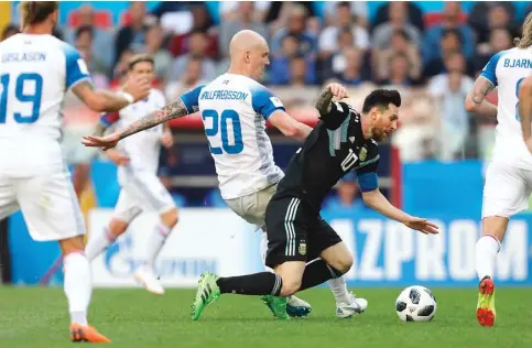  ?? ANGGER BONDAN/JAWA POS ?? TANPA AMPUN: Gelandang Islandia Emil Hallfredss­on menjatuhka­n penyerang Argentina Lionel Messi dalam kualifikas­i grup D Piala Dunia 2018 tadi malam WIB.