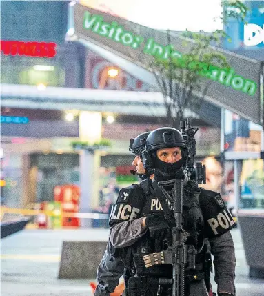  ?? VICTOR BIRO FOR THE TORONTO STAR ?? Toronto police stand guard at Yonge-Dundas Square after the latest of seven different shootings in the past three days.