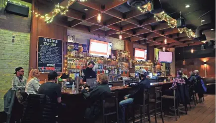  ?? ANGELA PETERSON/MILWAUKEE JOURNAL SENTINEL ?? Customers dine at Pete’s Pub on East Brady Street on Thursday. Gov. Tony Evers’ administra­tion is asking the Wisconsin Supreme Court to allow state health officials to issue a new order to limit capacity in indoor settings for about a month.