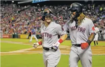  ?? MICHAEL AINSWORTH/THE ASSOCIATED PRESS ?? Boston Red Sox left fielder Andrew Benintendi, left, is congratula­ted by teammate Hanley Ramirez on his three-run home run against the Texas Rangers during Tuesday’s game in Arlington, Texas.