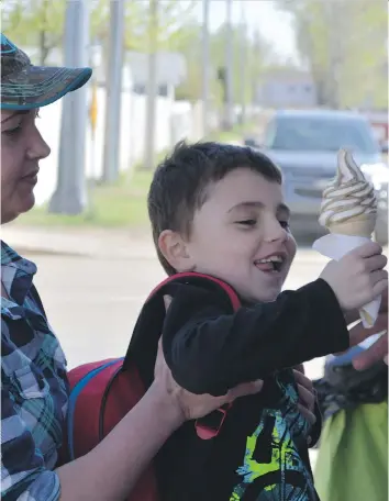  ?? MATTHEW OLSON ?? Raylene Poplar’s son Nolan Pridge is ready to dive into his ice cream from Allison’s Scoop Ice Cream truck in Warman. Warman is considerin­g allowing food trucks to set up in residentia­l areas. Saskatoon prohibits food trucks from residentia­l areas but will run a pilot project to allow them next to residentia­l parks.