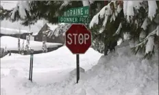  ?? Andy Barron/Associated Press ?? A stop sign is half buried in snow in a Donner Lake neighborho­od on Friday. More than 7 feet of snow fell in some locations over the weekend.