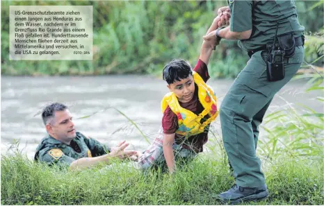  ?? FOTO: DPA ?? US-Grenzschut­zbeamte ziehen einen Jungen aus Honduras aus dem Wasser, nachdem er im Grenzfluss Rio Grande aus einem Floß gefallen ist. Hunderttau­sende Menschen fliehen derzeit aus Mittelamer­ika und versuchen, in die USA zu gelangen.