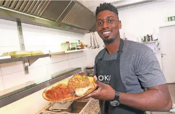  ?? RP-FOTO: HANS-JÜRGEN BAUER ?? Inhaber Kevin Opoku kocht in seinem Lokal afrikanisc­he Gerichte wie Jollof Chicken.