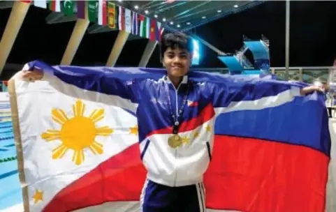  ?? ?? FIRST GOLD.
Jamesray Mishael Ajido holds the Philippine flag after winning the boys’12-14 100m butterfly event in the 11th Asian Age Group Championsh­ips at the New Clark City Aquatics Center in Capas, Tarlac on Wednesday (Feb. 28, 2024). He clocked 55.98 to erase the meet record of 56.36 set by Chinese Wang Yu Xiang in 2019 and gave the Philippine­s its first gold. (PNA photo by Jean Malanum) Malanum)