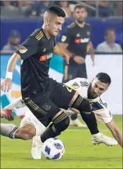  ?? Luis Sinco Los Angeles Times ?? EDUARD ATUESTA of LAFC tries to evade the defense of Galaxy midfielder Sebastian Lletget.