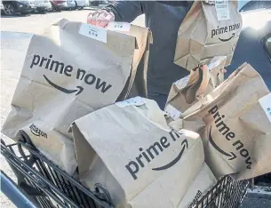  ?? JOHN MINCHILLO/THE ASSOCIATED PRESS FILE PHOTO ?? Amazon’s Whole Foods deal gives people more reasons to pay for Prime and buy Amazon devices.