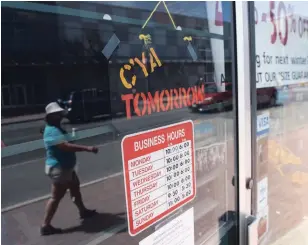  ?? JUSTIN TANG THE CANADIAN PRESS ?? A sign on a closed shop in Ottawa on Monday welcomes shoppers to return on Tuesday.