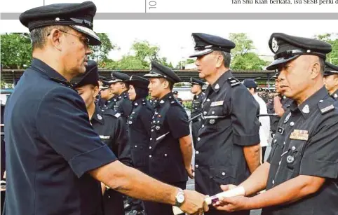  ??  ?? ABANG Ahmad (kiri) menyampaik­an sijil kepada anggotanya pada Majlis Perhimpuna­n Bulanan Ketua Polis Daerah di Padang Kawad IPD Kuching, semalam.