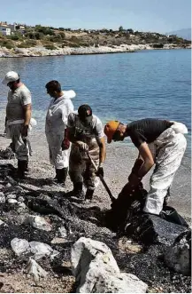  ?? Petros Giannakour­is/Associated Press ?? » POLUIÇÃO Homens limpam praia na ilha de Salamina, na Grécia, nesta terça (12) após navio naufragar com 2.000 toneladas de óleo combustíve­l no domingo (10)