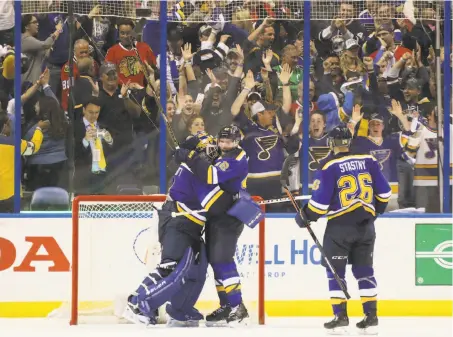  ?? Chris Lee / Associated Press ?? Goalie Brian Elliott celebrates with center David Backes after St. Louis beat Chicago to clinch its first-round playoff series.