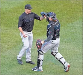  ?? AP-Nam Y. Huh ?? Miami Marlins relief pitcher Brandon Kintzler (left) and catcher Chad Wallach (17) celebrate a 2-0 victory over the Chicago Cubs in Game 2 of a National League wild-card baseball series Friday in Chicago. The Marlins won the series 2-0 to advance to the division series.