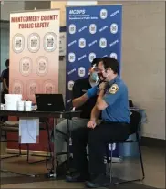  ?? PHOTO COURTESY OF MONTGOMERY COUNTY DEPARTMENT OF PUBLIC SAFETY ?? Lt. Joe Yochim of Narberth Ambulance receives a vaccine shot administer­ed by Dr. Alvin Wang, chief medical officer for the Montgomery County Department of Public Safety.