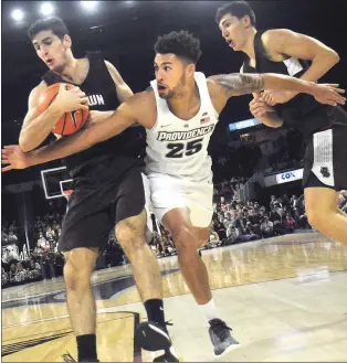  ?? Photo by Ernest A. Brown ?? PC sophomore guard Drew Edwards (25) battles against Brown defenders in the first half of Providence’s come-from-behind victory over the Bears in overtime Wednesday night at The Dunkin’ Donuts Center.