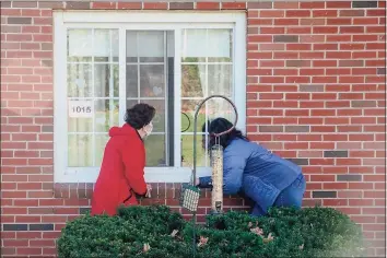  ?? Yehyun Kim / CTMirror.org ?? Jaclyn Petrizzo, of Manchester, left, and Kim Boulette, of Vernon, visit their mother and grandmothe­r, Mildred Christador­e, through the window.