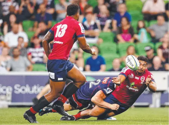  ?? Picture: GETTY IMAGES ?? Chris Feauai-Sautia tries to pop a pass to Reds teammate Samu Kerevi in last night’s loss to the Rebels.