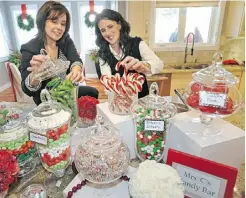  ?? Ed Kaiser/ Edmonton Journal ?? AMR Design designers Michelle Pollock, left, and Brenda Brix create a candy bar using beautiful glass apothecary jars.