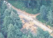  ?? AP PHOTO ?? Workers gather in a staging area Saturday, near Steilacoom, Wash., near the site on Ketron Island in Washington state where an Horizon Air turboprop plane crashed Friday after it was stolen from Sea-tac Internatio­nal Airport.