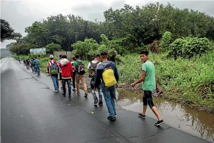  ?? AP ?? Honduran migrants walk along a highway in Cocales, Guatemala, on their way to the US border yesterday.