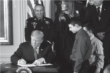 ?? ASSOCIATED PRESS ?? President Donald Trump signs a presidenti­al memorandum declaring the opioid crisis a public health emergency in the East Room of the White House, in Washington.
