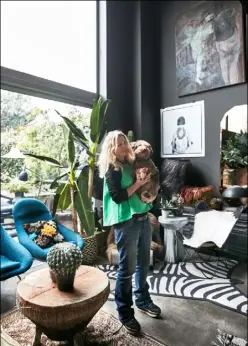  ??  ?? Portrait Abigail Ahern with her Welsh terrier Maud Dining area This space is painted Ahern’s own ‘Hudson Black’ – with the colour used on the walls, floor and ceiling. The marble dining table and chairs are all from the Ardingly Antiques and Collector’s Fair. The retro green, black and white lampshade is from another antiques fair in Nottingham, while the iron ‘Drum’ side table beside it is from Atelier Abigail Ahern Stockist details on p152