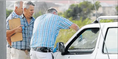  ?? Pictures: WERNER HILLS ?? FINE-TOOTH COMB: Officers gather evidence from the bullet-ridden windscreen of a bakkie caught in the crossfire