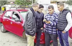  ?? — AFP ?? CASABLANCA: Moroccan taxi drivers check the Uber app as they wait for customers on Jan 6, 2017.